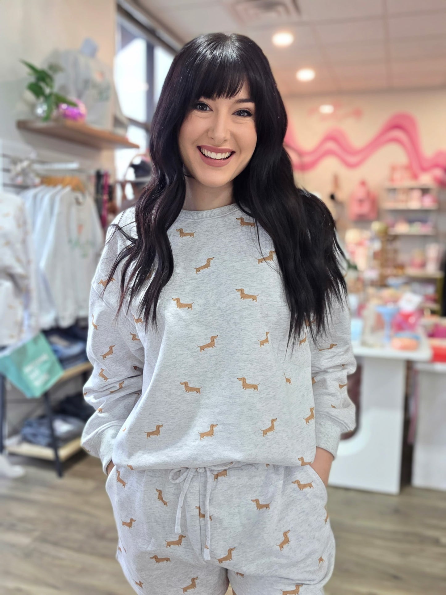 Woman wearing a gray pajama set with dog pattern in a store setting